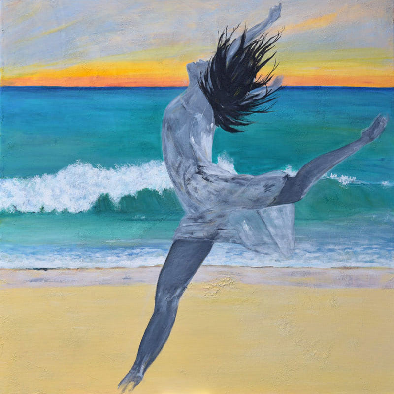 Junge Frau springt am Strand aus Freude